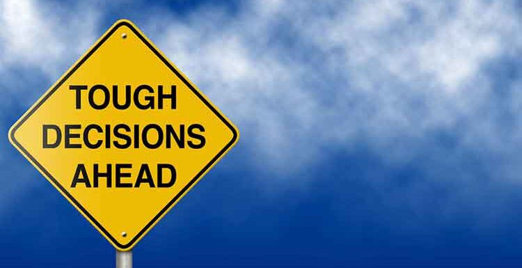 a yellow sign with the words tough decisions ahead