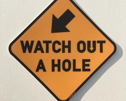 a sign that says watch out a hole